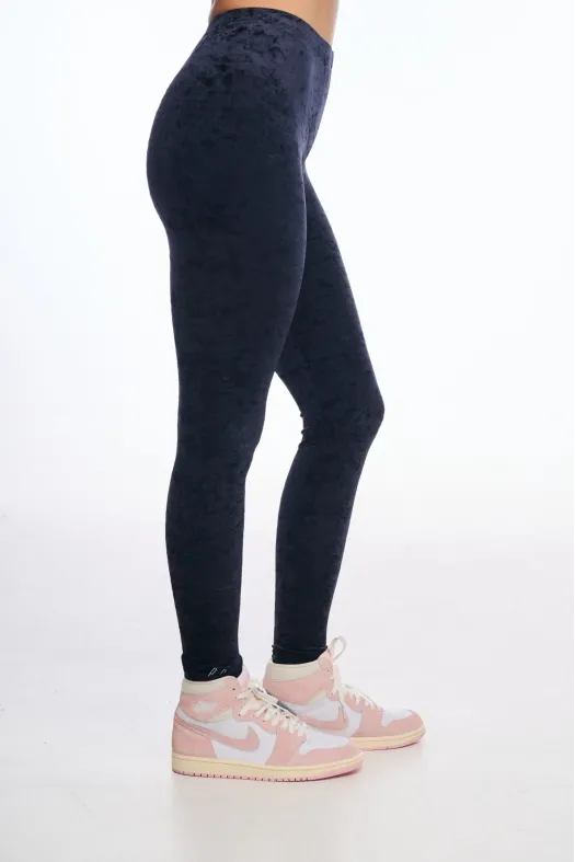 Person wearing black leggings and pink sneakers on a white background