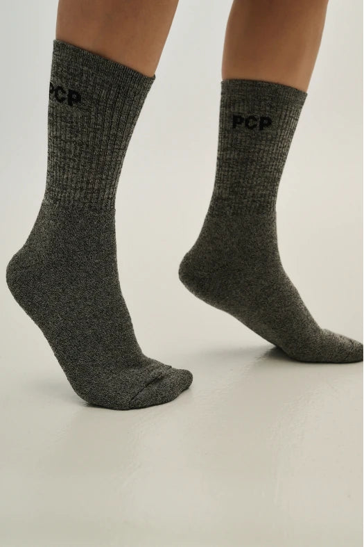 Gray socks with 'PCP' branding on a light gray background