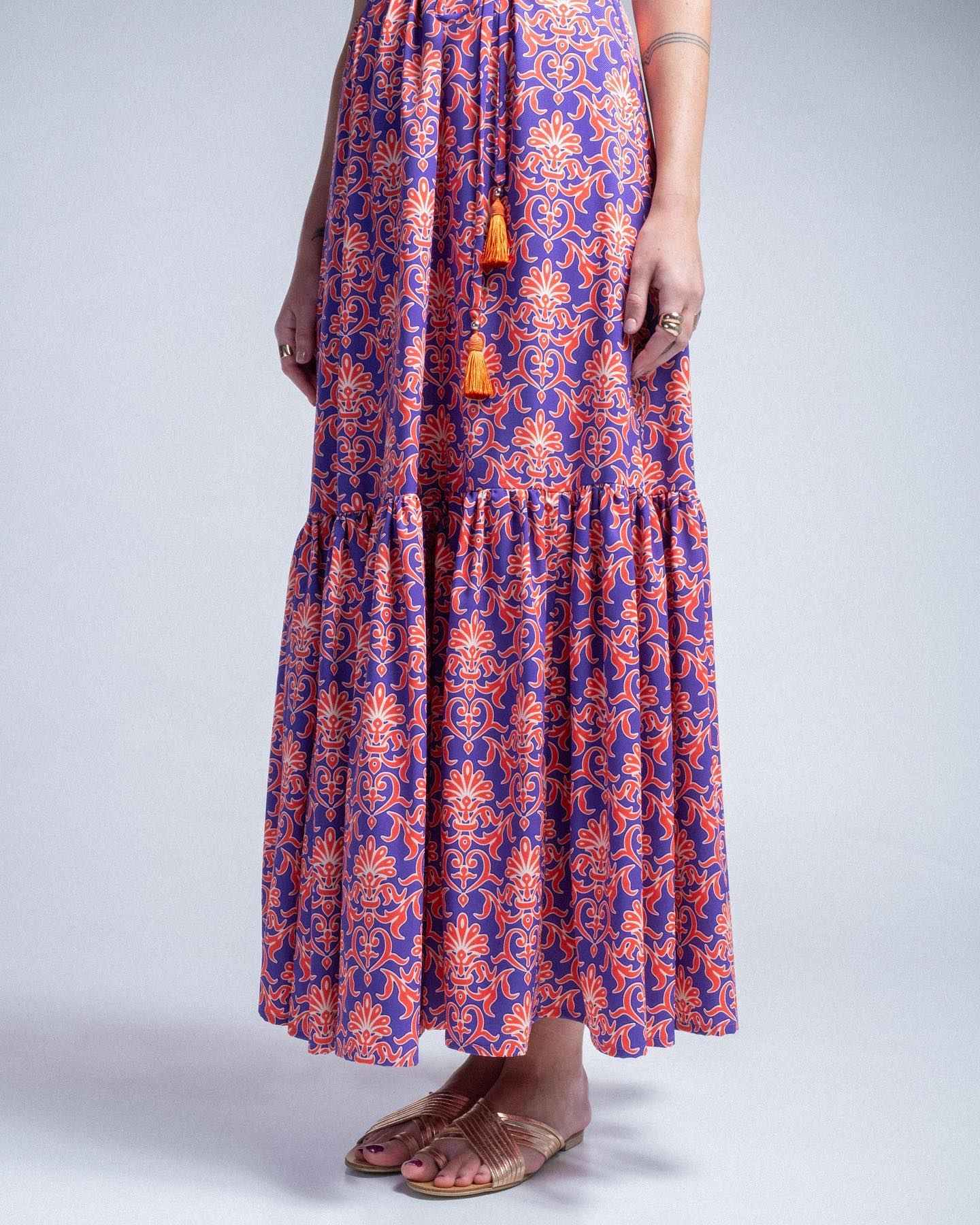 Long dress with a floral pattern in blue and orange on a plain background
