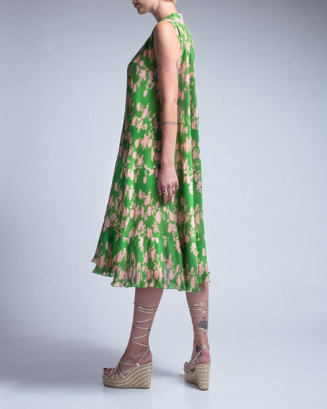 Green floral dress worn by a person on a plain background