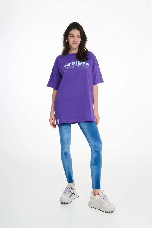 Person wearing a purple oversized t-shirt and blue leggings on a white background