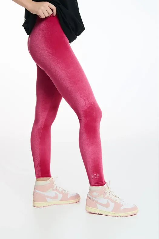 Person wearing bright pink leggings with a white background