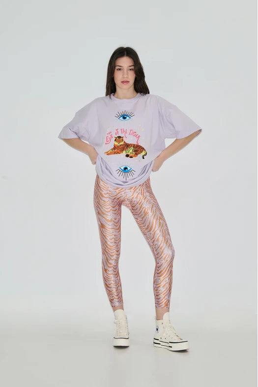 Person wearing a graphic t-shirt and patterned leggings on a white background