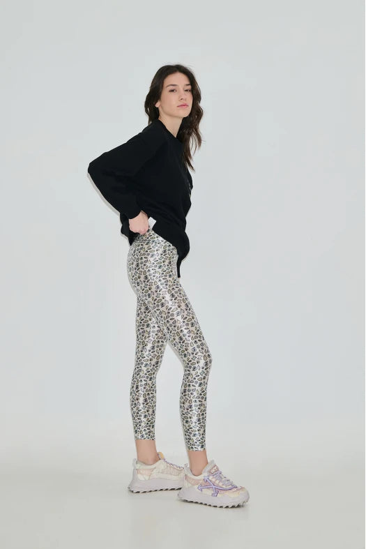Woman wearing black sweater and patterned leggings on a white background