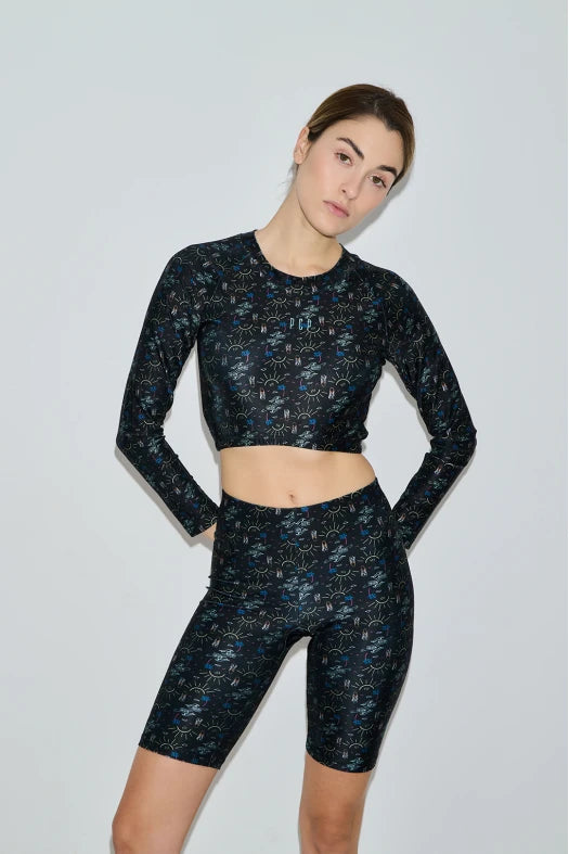 Woman wearing a black floral athletic outfit on a light gray background