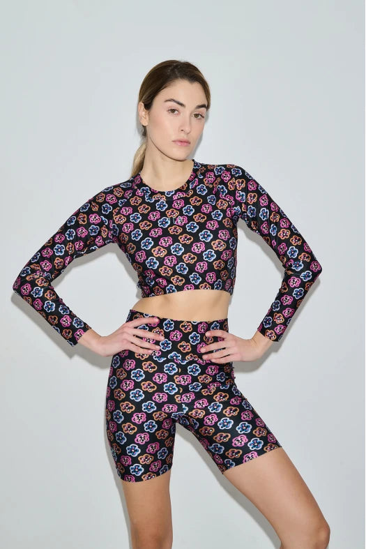 Woman wearing a colorful floral athletic outfit on a light gray background