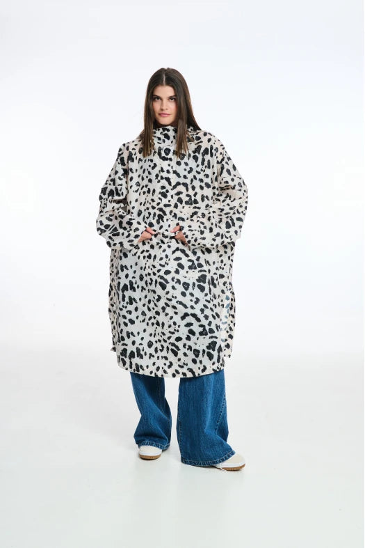 Person wearing a long, patterned coat on a white background