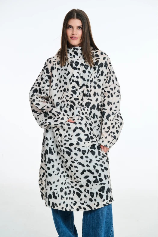 Person wearing a long, patterned coat with a white background