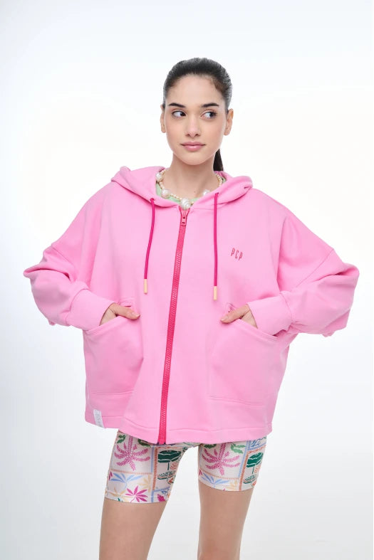 Person wearing a pink hoodie with a zipper on a white background