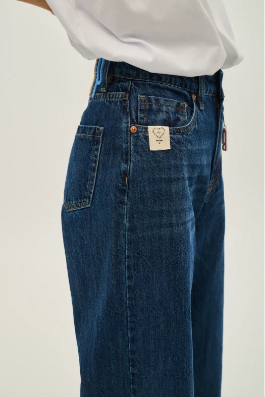 Blue jeans with a visible brand label on a plain background