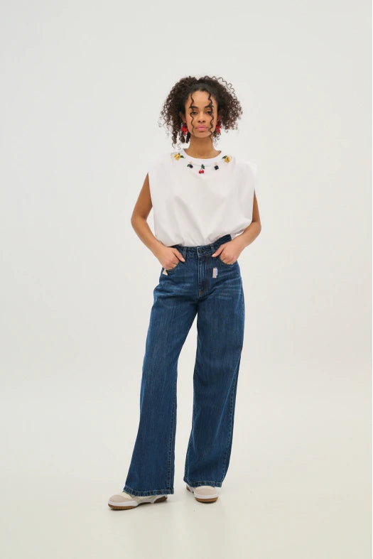 Woman wearing a white top and blue jeans on a white background