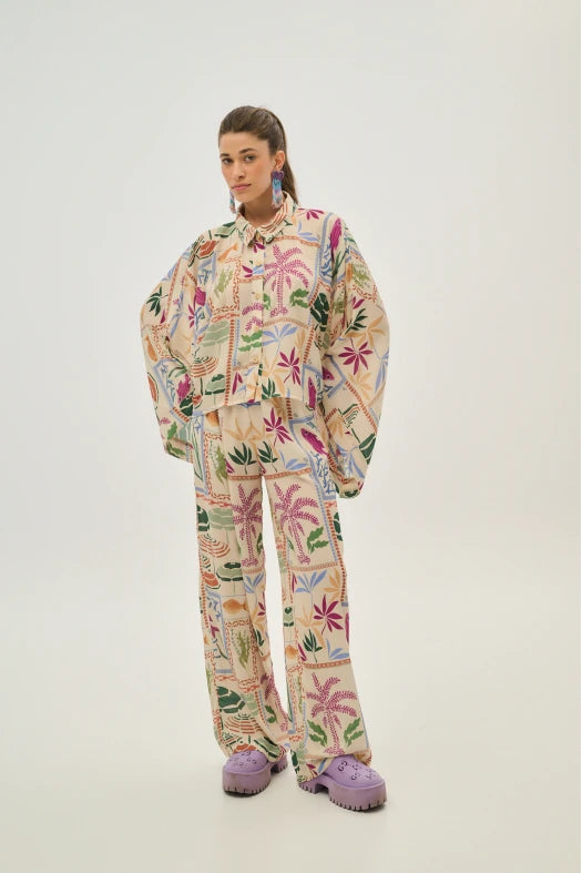 Person wearing a colorful floral outfit with matching shoes on a white background