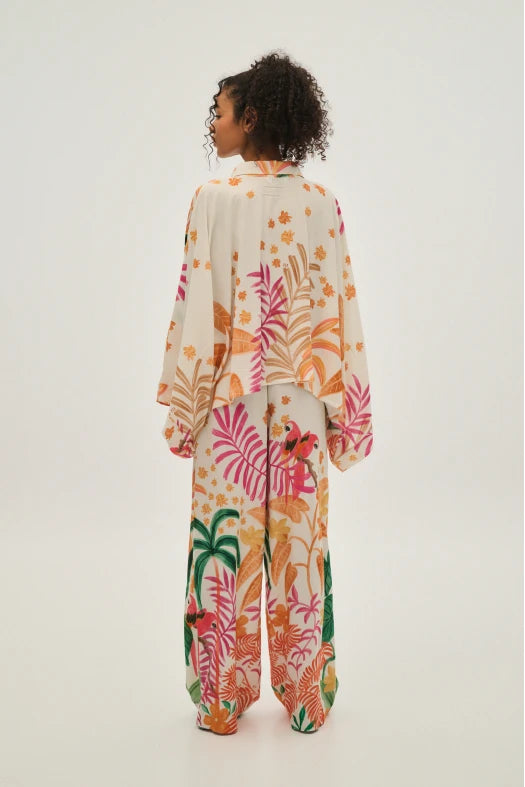 Person wearing a colorful floral onesie on a white background