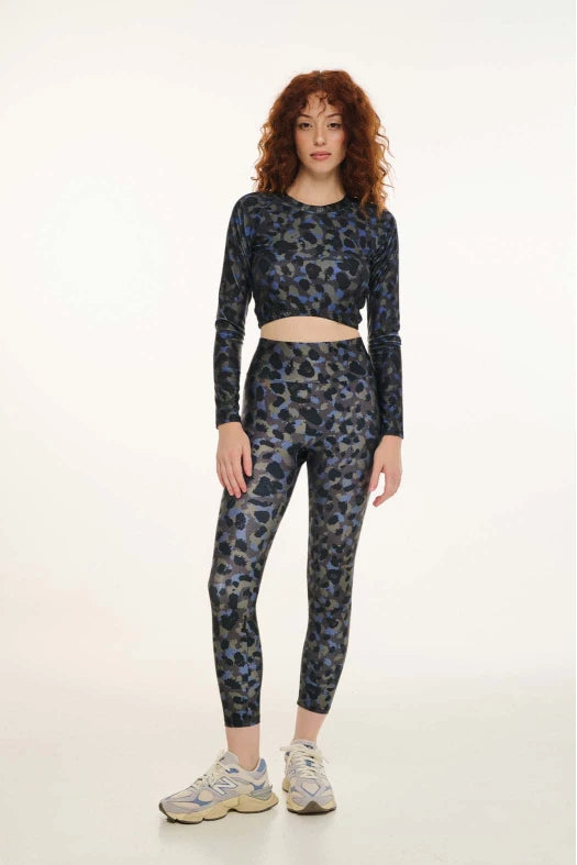 Woman wearing a black and blue patterned outfit on a white background