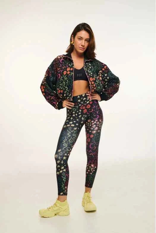 Person wearing a colorful floral jacket and leggings on a white background