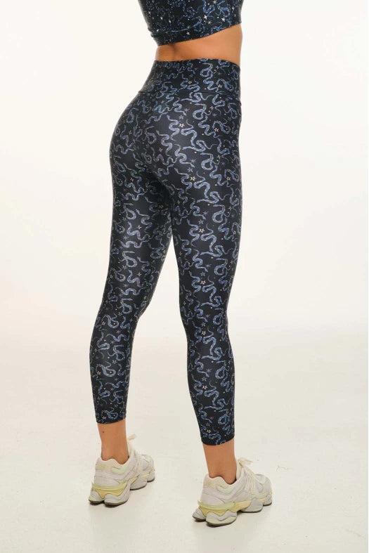 Person wearing navy leggings with white pattern on a white background