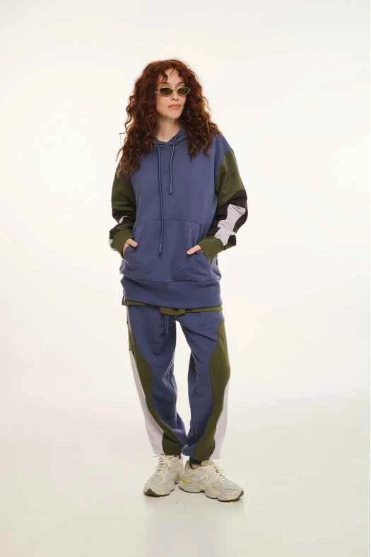 Person wearing a blue and green tracksuit on a white background