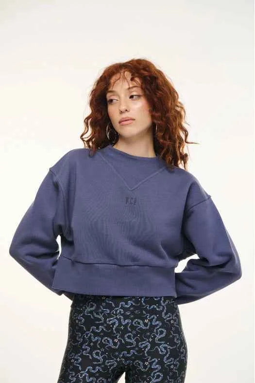 Woman wearing a blue sweater with a logo on a white background