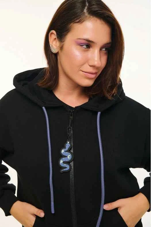 Person wearing a black hoodie with a snake design on a white background