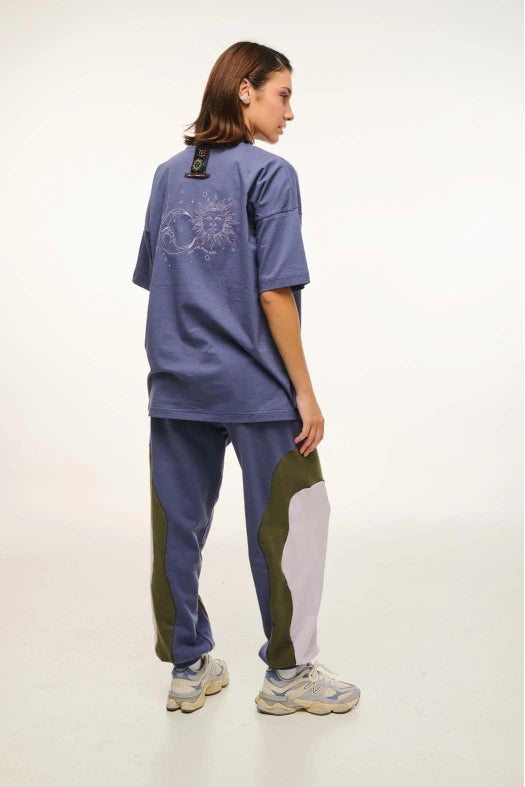 Person wearing a blue outfit with green and white accents on a plain background