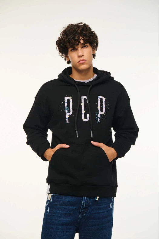 Person wearing a black hoodie with 'PCP' logo on a white background