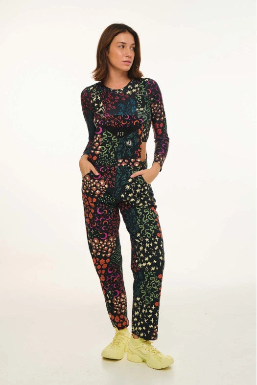 Person wearing a colorful patterned outfit with yellow shoes on a white background