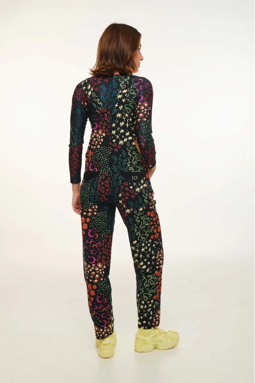 Person wearing a colorful patterned jumpsuit on a white background