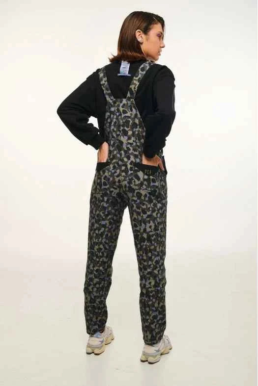 Person wearing camouflage overalls and a black shirt on a white background