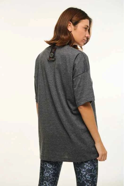 Person wearing a long gray shirt with a white background