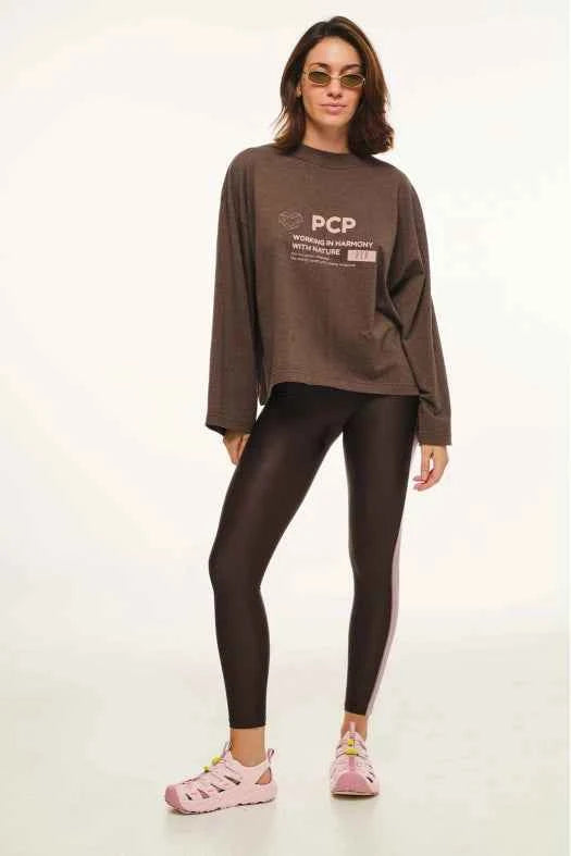 Woman wearing a brown sweatshirt and leggings with 'PCP' branding on a white background