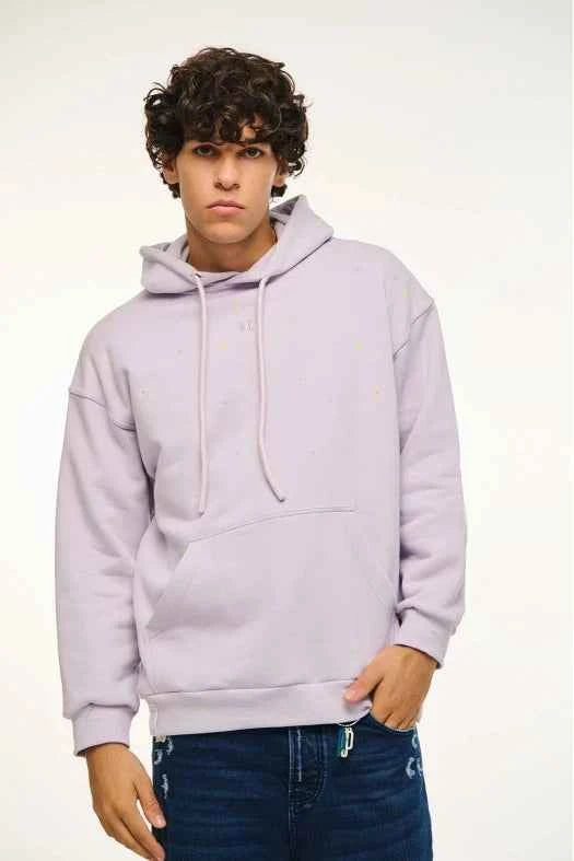 Person wearing a light purple hoodie and dark jeans on a white background