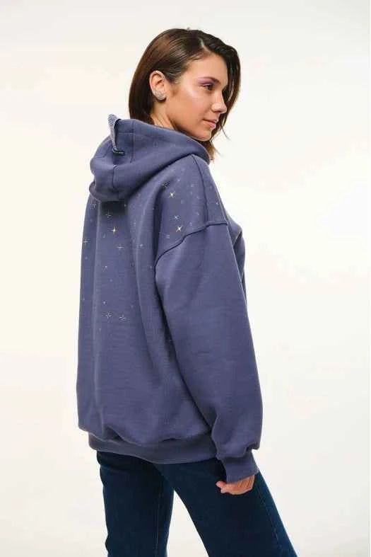 Person wearing a purple hoodie with star patterns on a white background