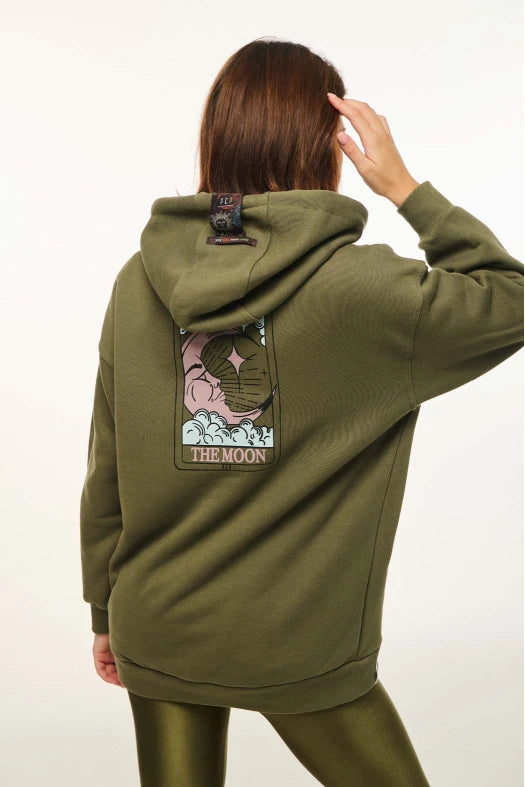 Person wearing a green hoodie with a 'The Moon' patch on the back against a white background