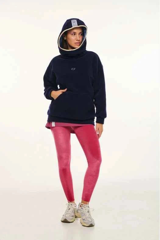 Person wearing a navy hoodie and pink leggings on a white background