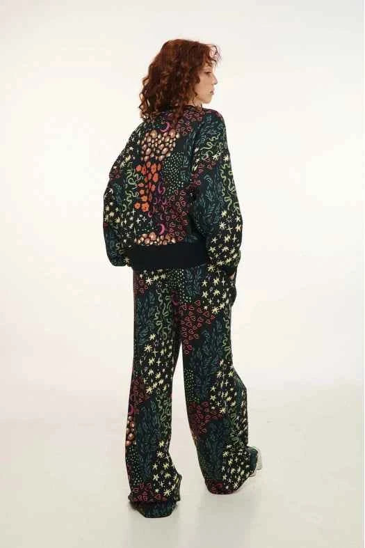 Person wearing a colorful patterned outfit on a white background