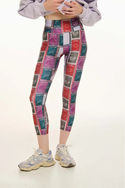 Person wearing colorful patterned leggings on a white background