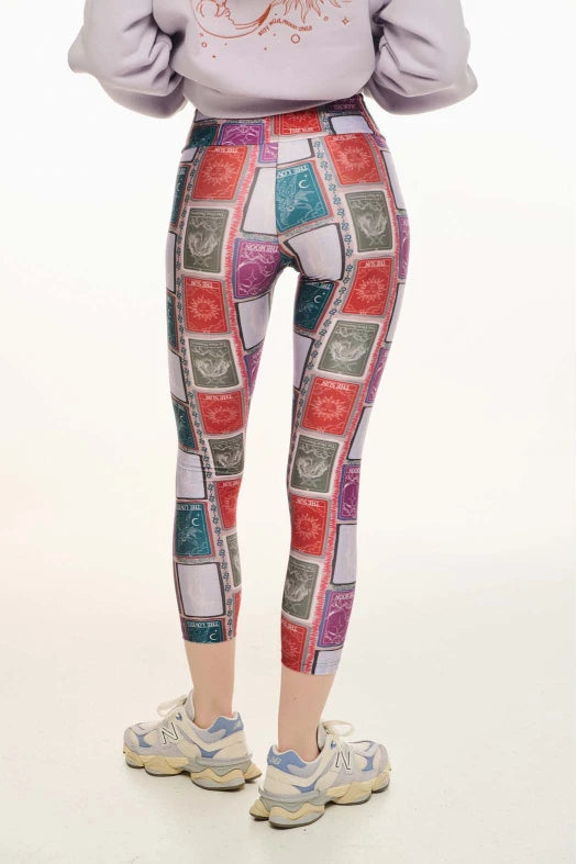 Person wearing colorful patterned leggings on a white background