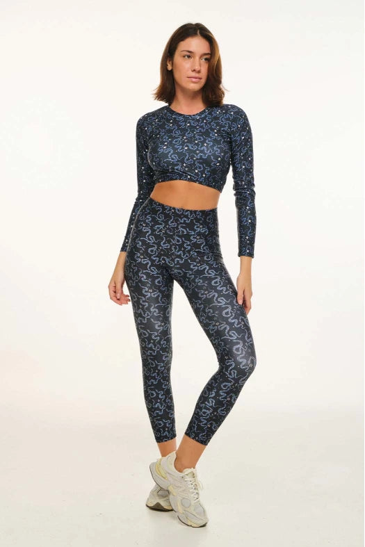 Woman wearing a blue patterned athletic outfit on a white background