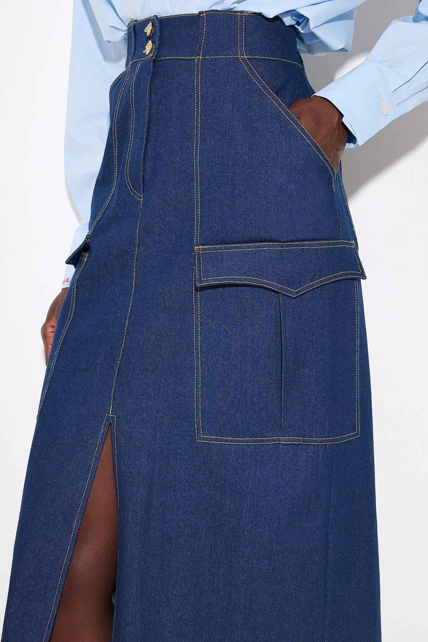 Blue denim skirt with a front slit on a white background