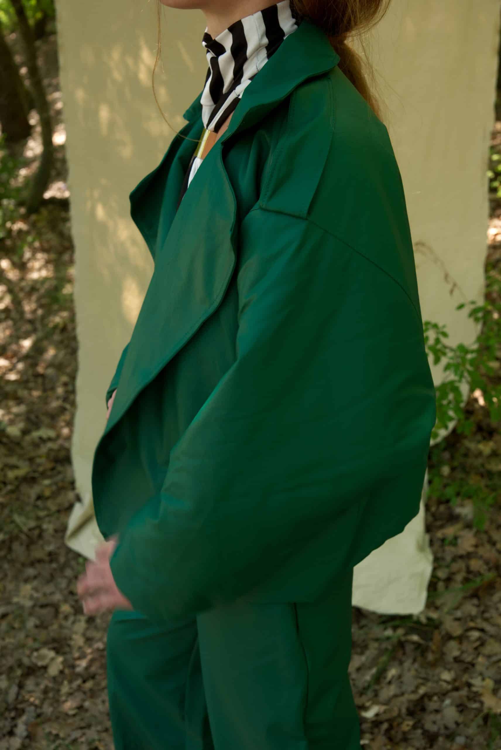 Person wearing a green suit with a zebra-striped shirt in a forest setting