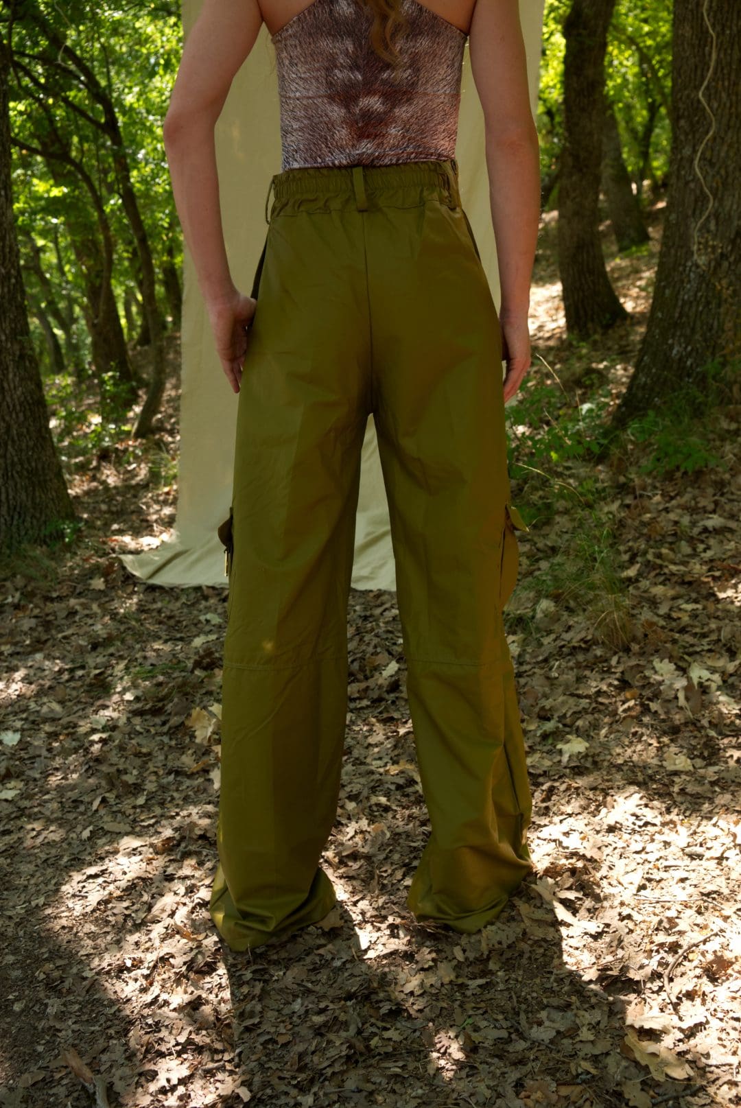 Person wearing green pants standing in a forest