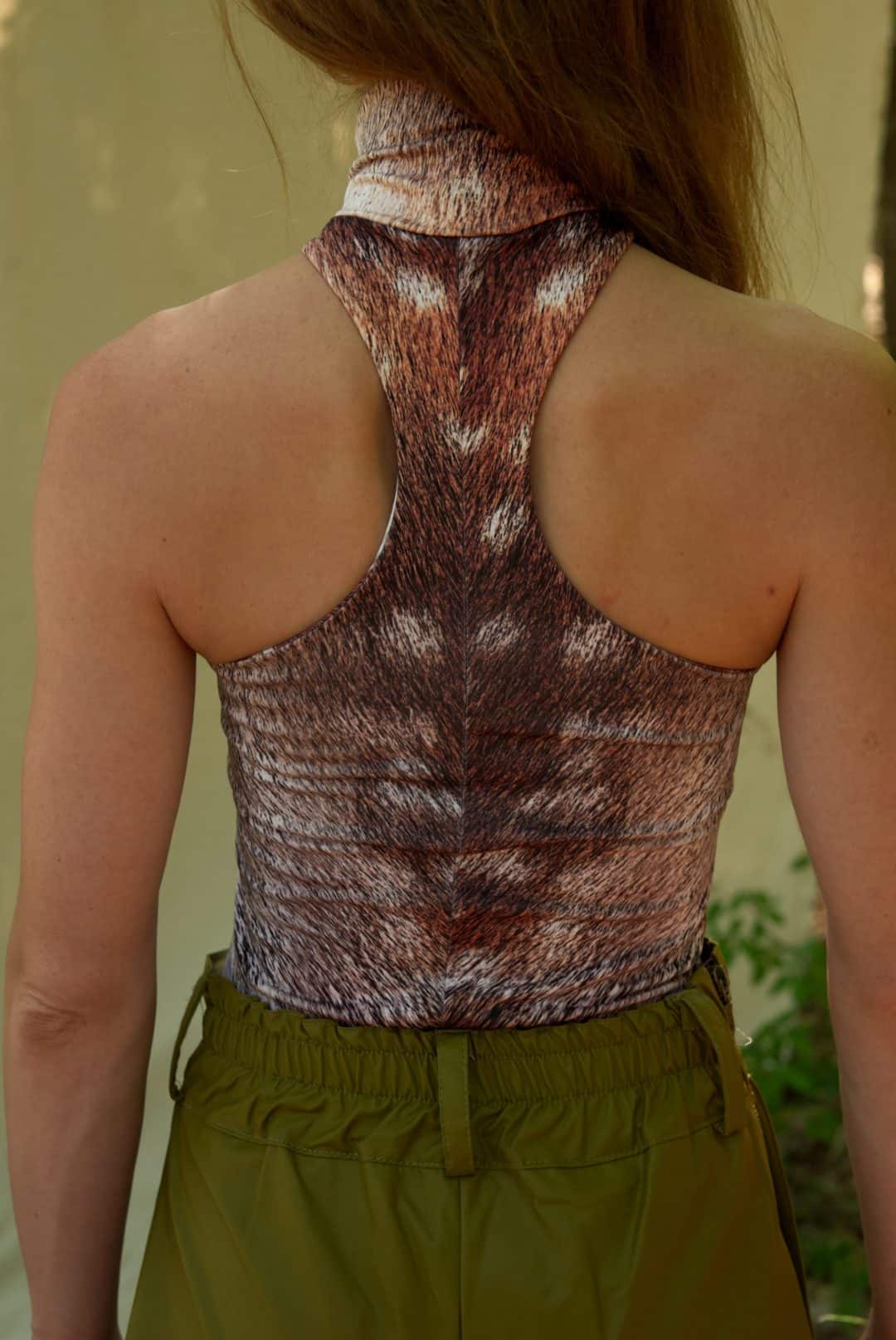 Person wearing a patterned tank top with a blurred background