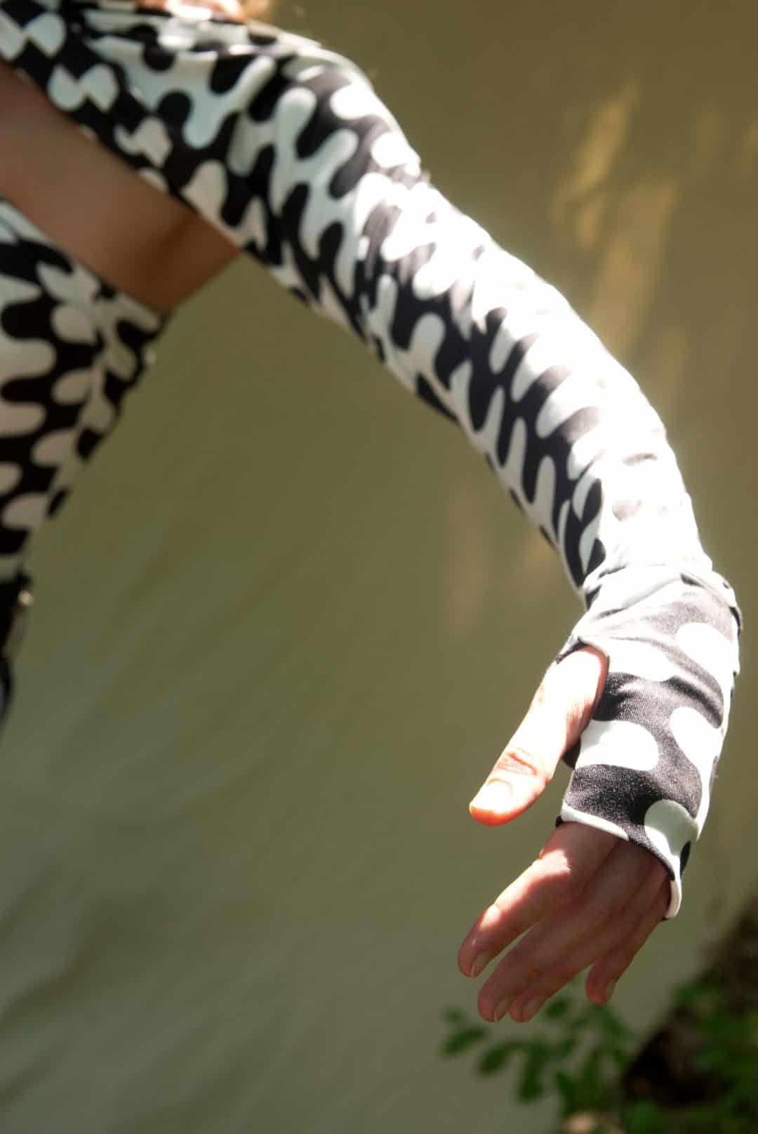 Black and white patterned sleeve on a person against a neutral background