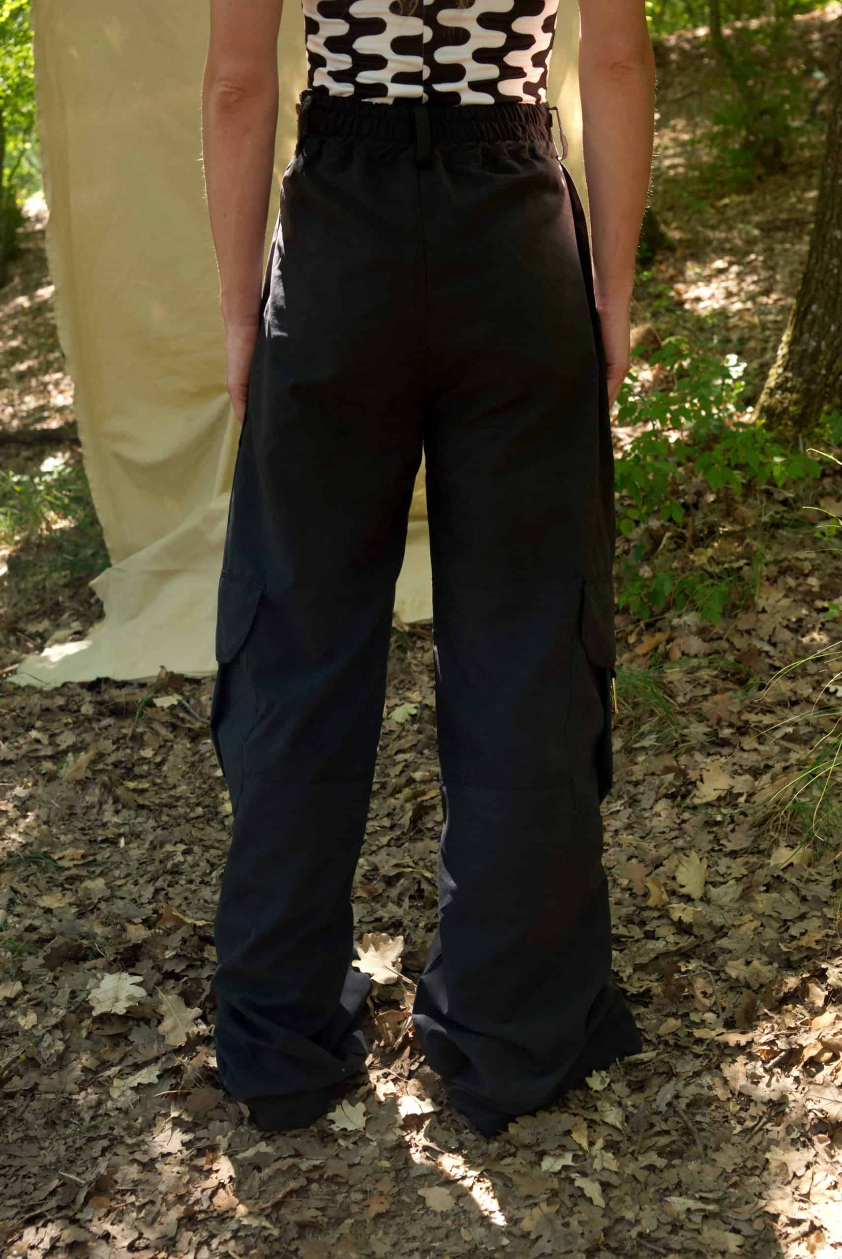 Person wearing black pants standing in a forest setting