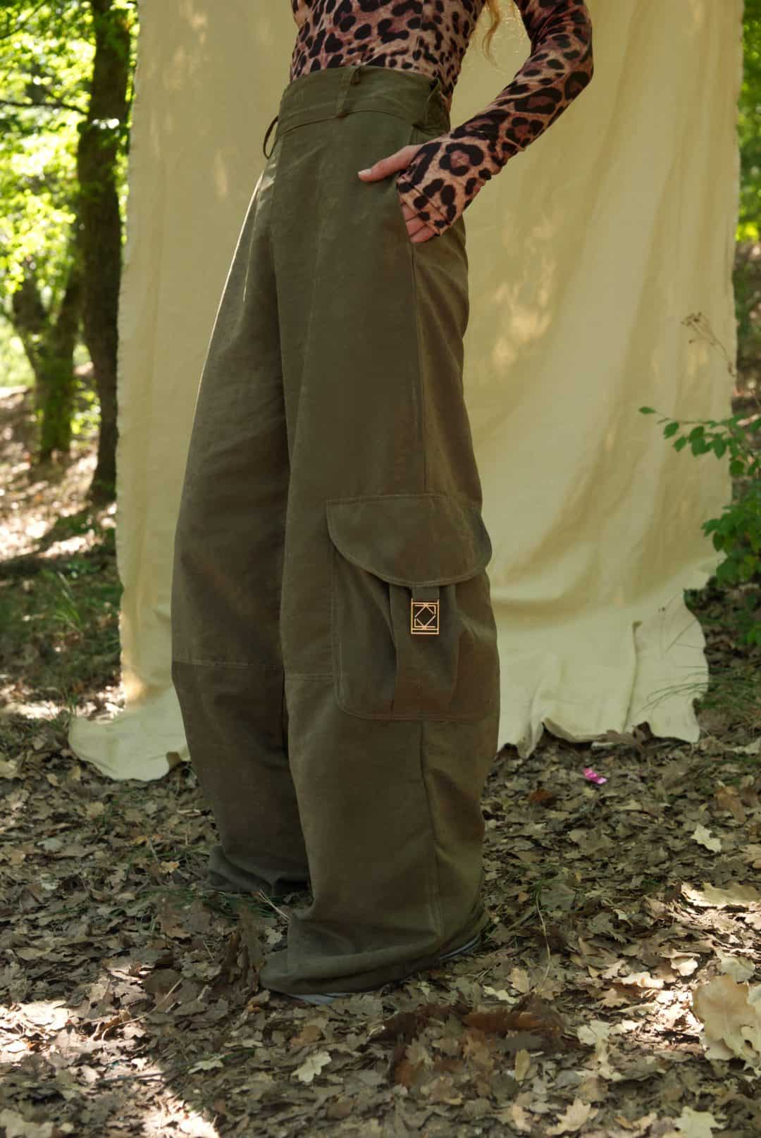 Person wearing olive green cargo pants in a forest setting