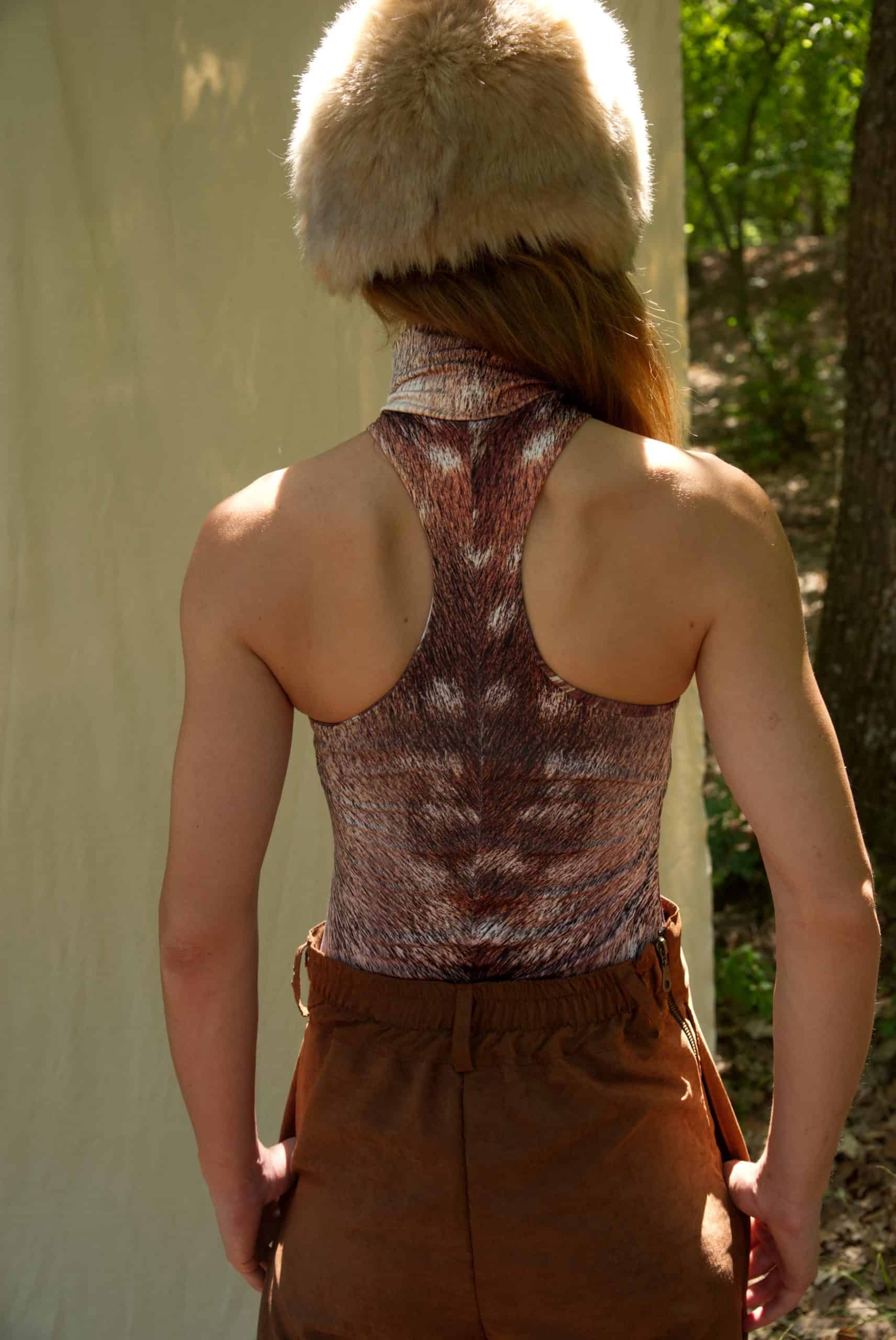 Person wearing a fur hat and patterned top outdoors