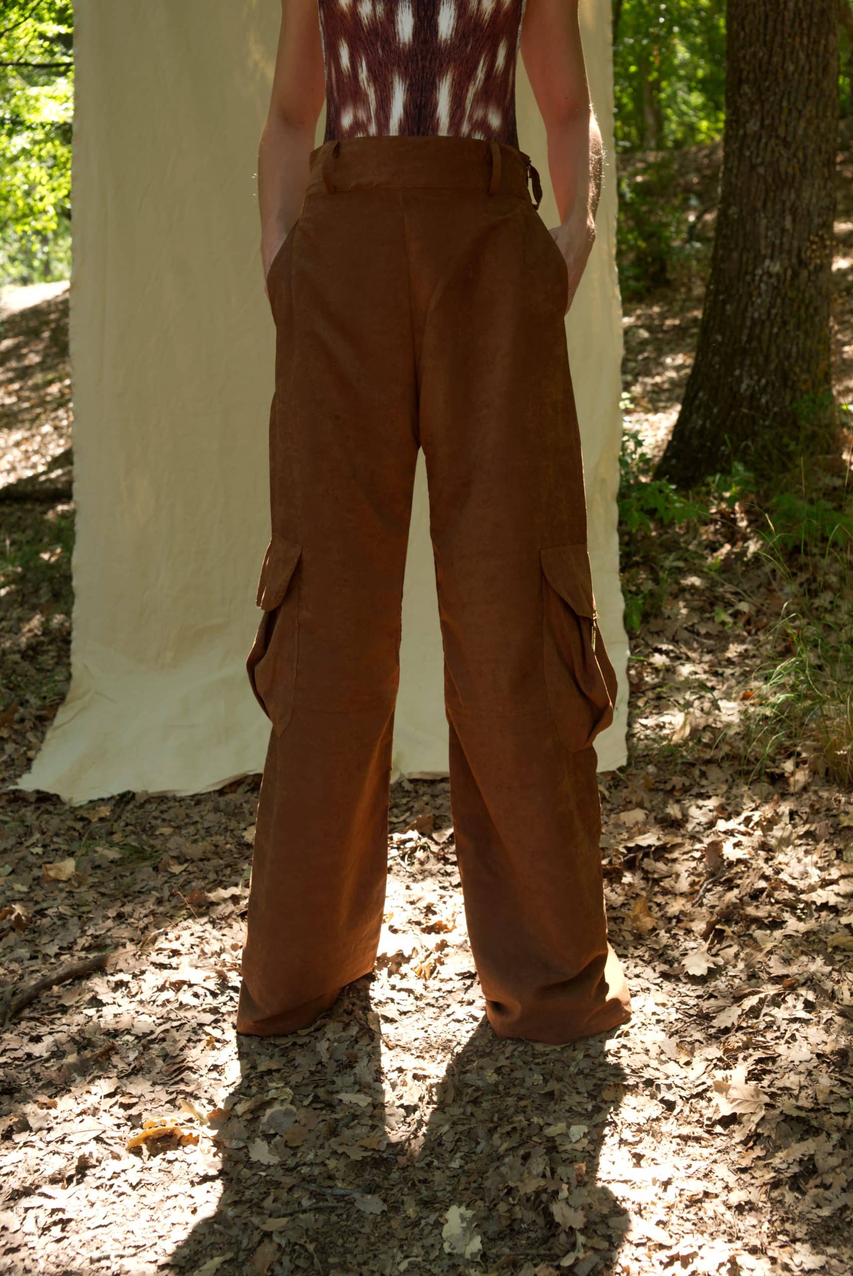 Person wearing brown cargo pants and a tie-dye top in a forest setting