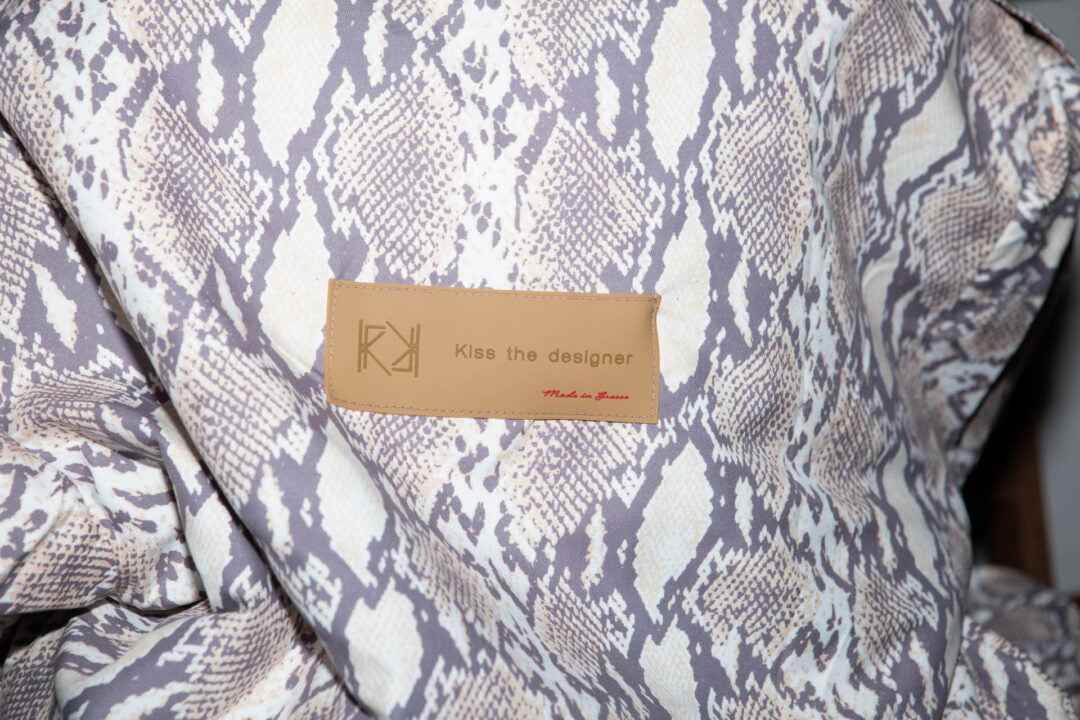 Snakeskin-patterned garment with a brown label.