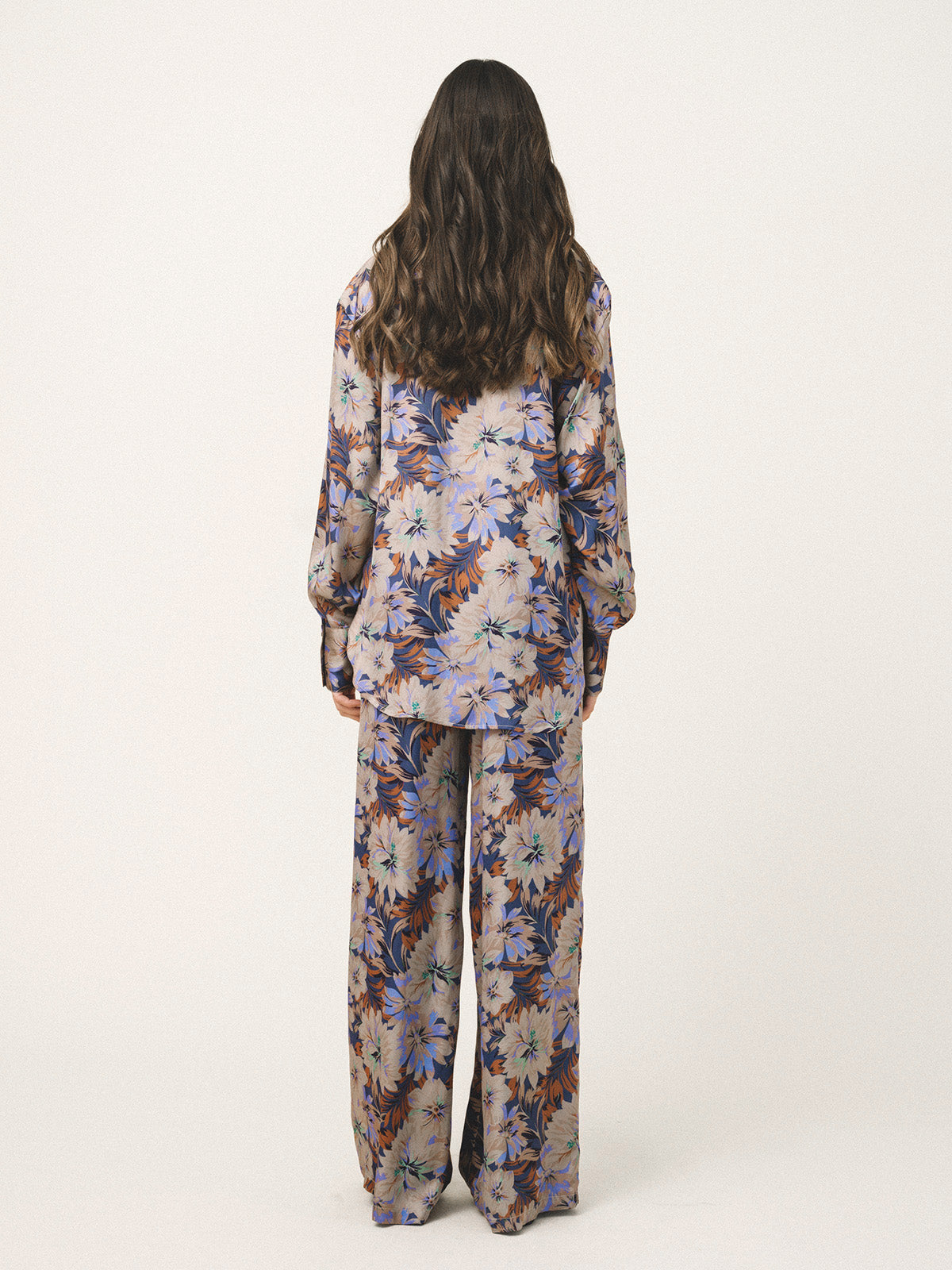 Person wearing a floral pajama set on a white background