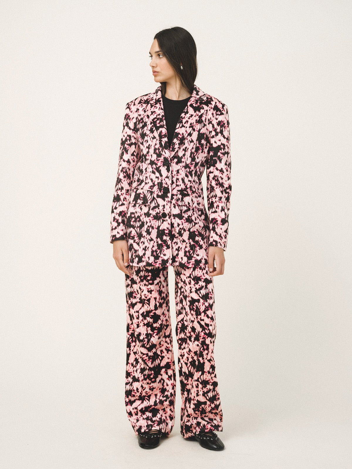 Person wearing a pink floral pajama set on a white background